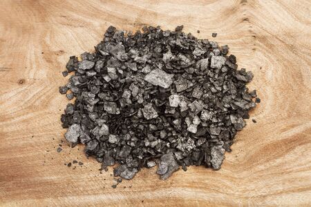 Black salt in flakes on a wooden tableの写真素材