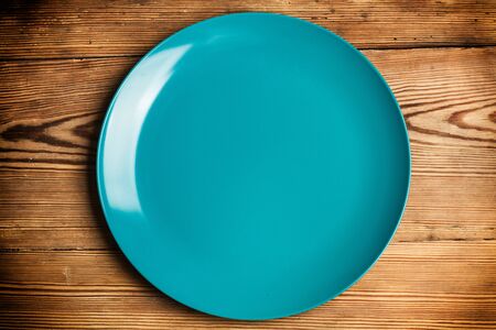 A blue plate on a wooden tableの写真素材
