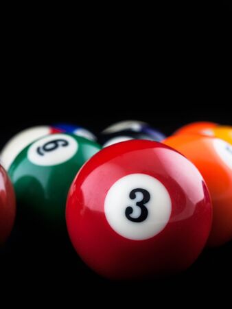 Solid and stripes pool balls on a dark backgroundの写真素材