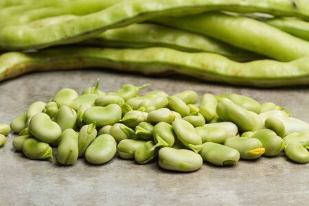 Raw broad beans on a marble table