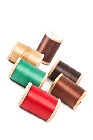 Spools of colored threads on a white background
