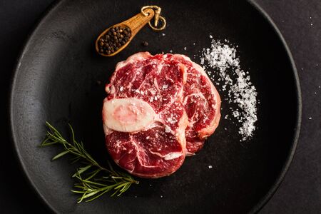 Raw osso buco slices on a black plateの写真素材