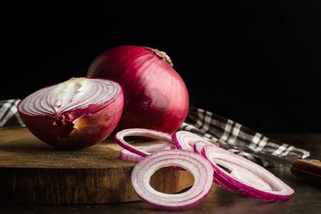 Purple onions on a wooden kitchen boardの写真素材