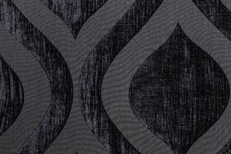 A texture of a black wool textile with ornaments
