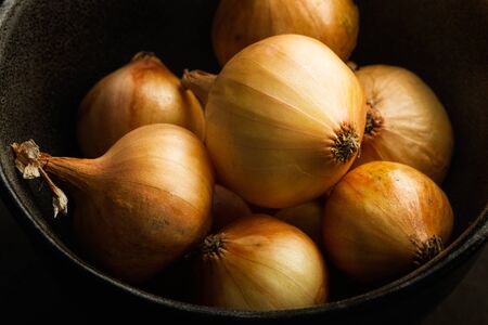 Small white french onions in a dark bowlの写真素材