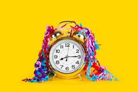 Old alarm clock on a yellow background