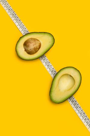 A halved avocado on a tailor measuring tape