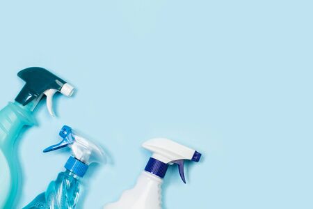 Assorted cleaning product bottles on a light blue background with copy spaceの写真素材