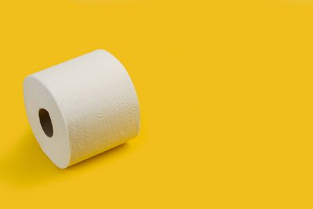 Toilet paper roll on a yellow background with copy spaceの写真素材