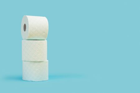 Three toilet paper rolls in a heap on a light blue backgroundの写真素材