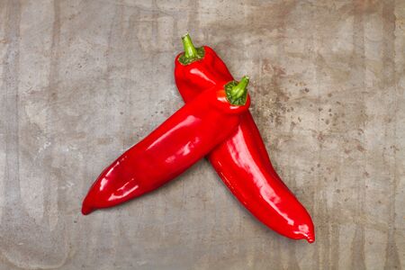 Red sweet italian peppers on a rusted metal table in a top viewの写真素材