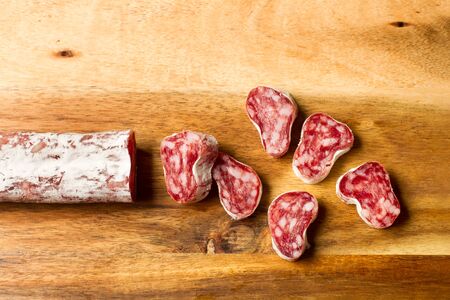 Sliced cured pork sausage on a wooden table