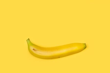 One banana on a yellow background with copy spaceの写真素材