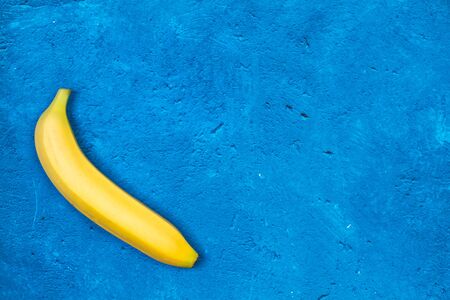 One banana on a textured classic blue backgroundの写真素材