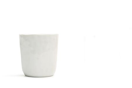 A textured white ceramic glass on a white backgroundの写真素材