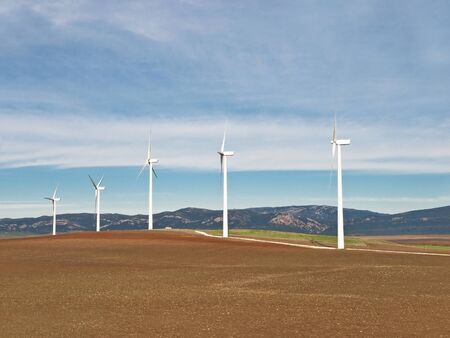 A rural scene with electric generator windmills in a cloudy dayの写真素材