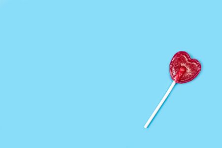 One red heart shaped lollipop on a light blue backgroundの写真素材