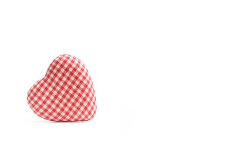 A heart made with red and white checked fabric isolated on a white background and with copy spaceの写真素材