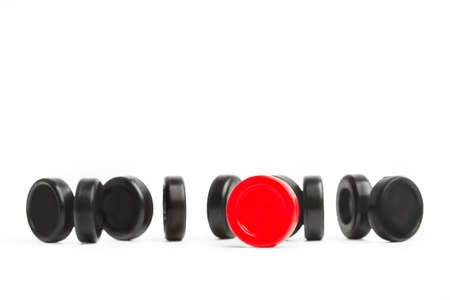 Red and black checkers chips on a white backgroundの写真素材