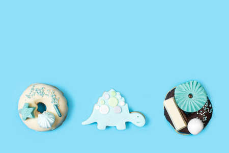 Donuts and cookies for a birthday on a light blue background in a top view