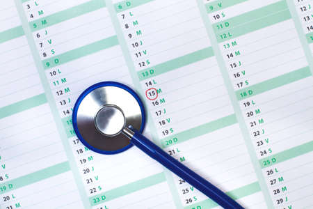 A stethoscope on a calendar in a top viewの写真素材