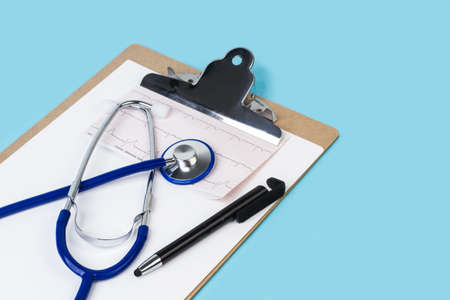 A stethoscope on an electrocardiogram and on a clipboardの写真素材