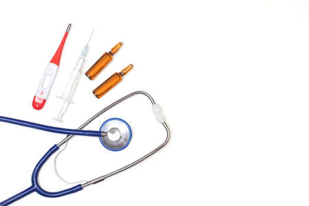 A stethoscope, a thermometer and a syringe on a white background in a top viewの写真素材