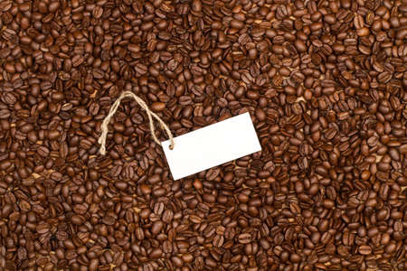 Texture of coffee grains in a close up view with a blank white label