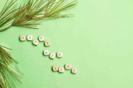Happy new year greeting made with wooden letter cubes on a green background