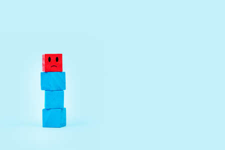 A human shape made with colored square wooden blocks on a light blue background with copy spaceの写真素材