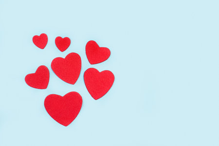 Red paper hearts on a light blue background with copy spaceの写真素材