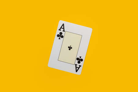 An ace of clubs on a yellow background in a close up viewの写真素材