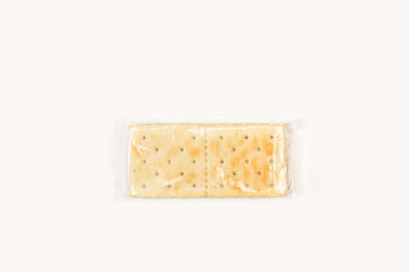 Cracker biscuits in a plastic packaging on a white background in a top view