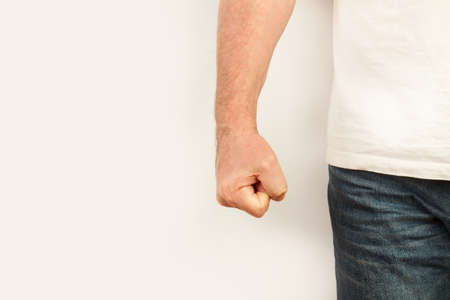 Man with his fist clenched on a white background