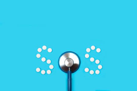 SOS word made with medical pills and part of a stethoscopeの写真素材