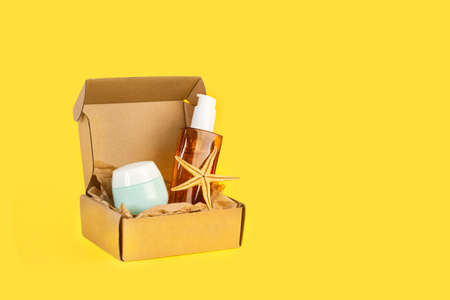 Moisturizer cream and lotion bottles in a cardboard box on a yellow background
