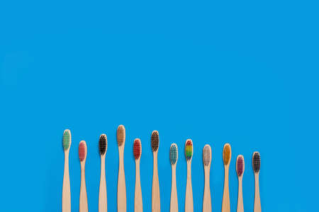 Colored bamboo wood toothbrushes on a blue backgroundの写真素材