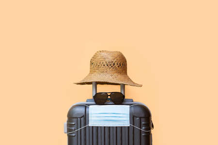 A suitcase with a hat, sunglasses and surgical maskの写真素材