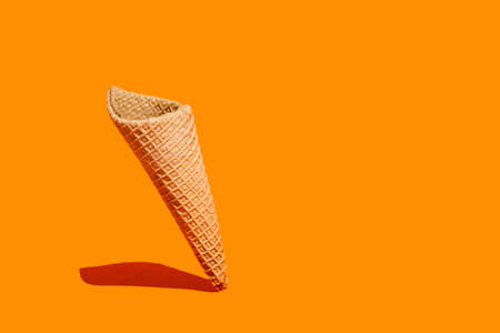 Sweet wafer cone on an orange background with copy spaceの写真素材