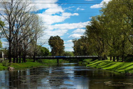 A brook with a bridge in a park in a sunny day