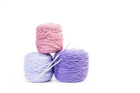Pink and violet wool balls on a white background with copy spaceの写真素材