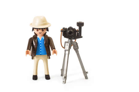 A toy photographer with tripod and camera on a white backgroundのeditorial素材