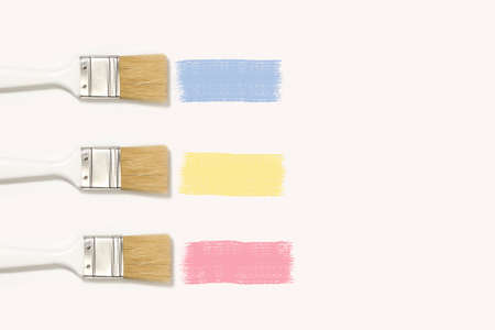 Three paintbrushes with pastel colored paint trace on a white backgroundの写真素材