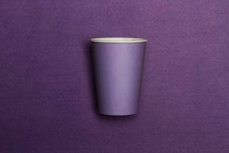 A purple disposable cup on a purple background with copy spaceの写真素材