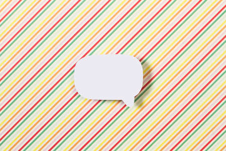 Blank white speech bubble with copy space on a multicolored striped background