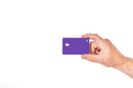 Man hand holding a purple credit card on a white backgroundの写真素材