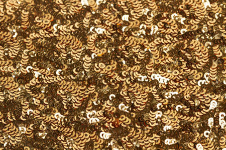 Background of a cloth with golden sequins in a close up view