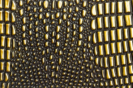 A texture of a golden plastic cloth with bubbles in a close up view