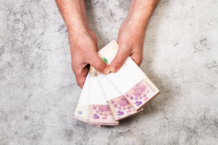 Man hands holding bundles of money on a stone backgroundの写真素材