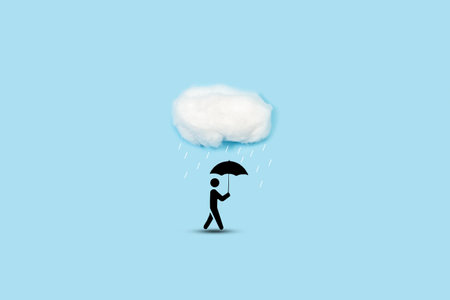 A paper man with an umbrella under a cloud made with cotton on light blue backgroundの写真素材